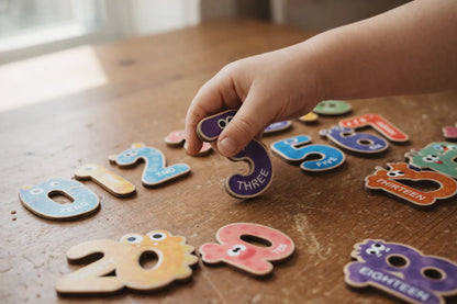 Hands arranging magnetic decals on activity wall