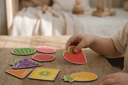 Child playing with magnetic fruit puzzle magnets